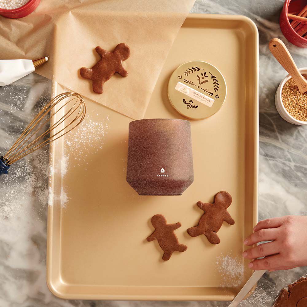 Thymes Gingerbread Large Candle is a Holiday Fragrance on gold cooking tray with Gingerbread man cookies image number 3